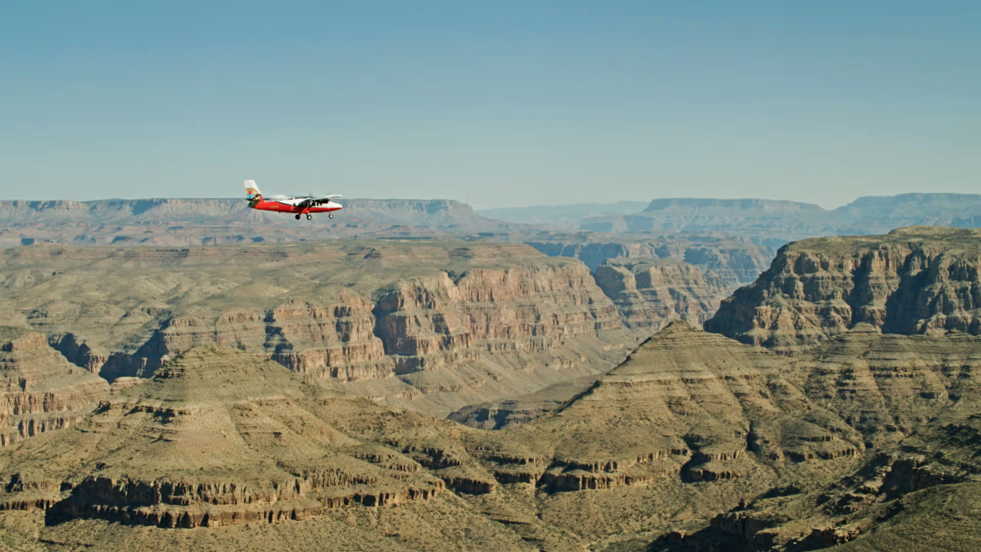 New paint airplane flying over Grand Canyon with hazy background